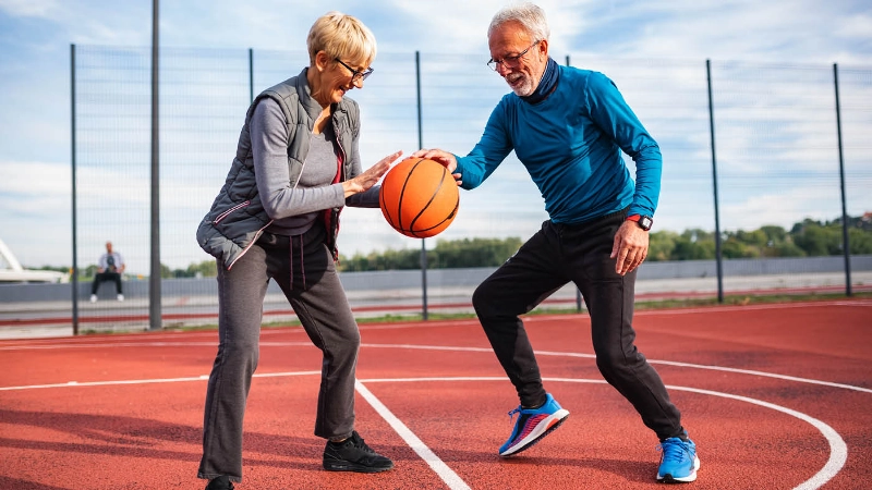 Zwei Senioren spielen gemeinsam Basketball.