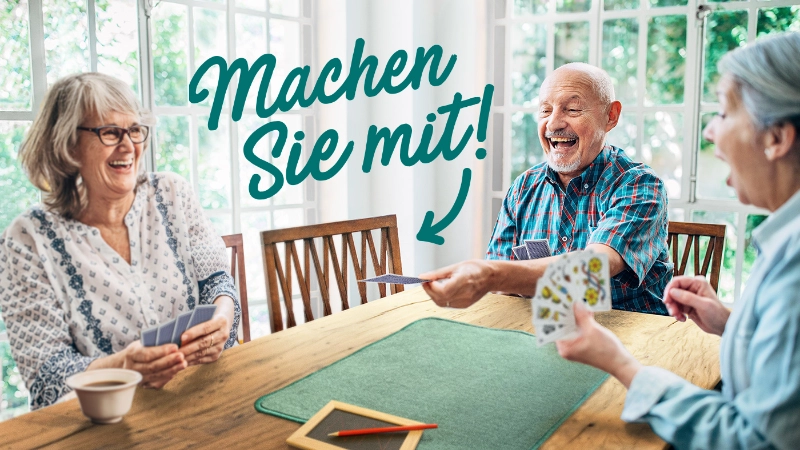 Ein älterer Mann mit Velohelm steht in seinem Wohnzimmer und schaut auf sein Handy