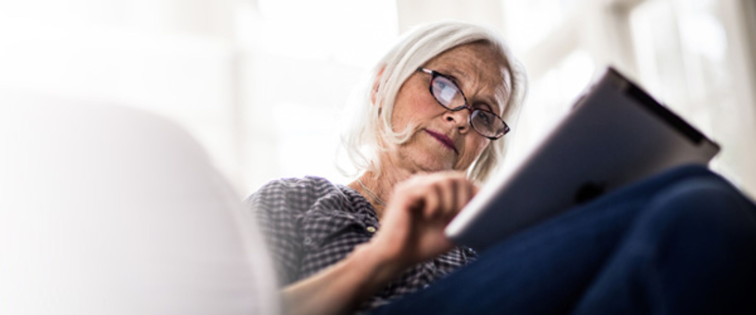 Une dame d'un certain âge qui travaille sur son ordinateur portable.