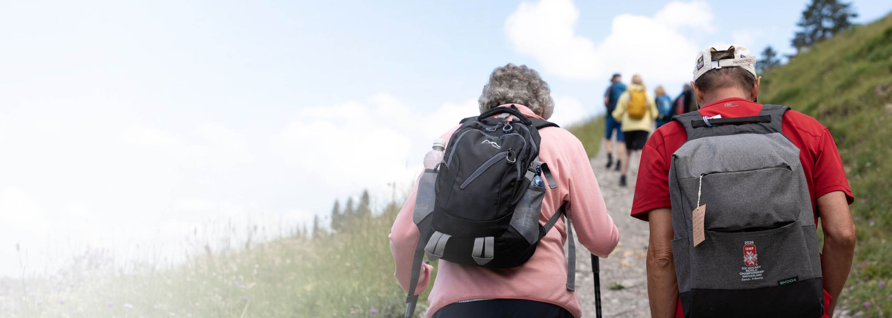 Deux personnes marchent sur un sentier en pleine nature, dos à l’appareil photo.