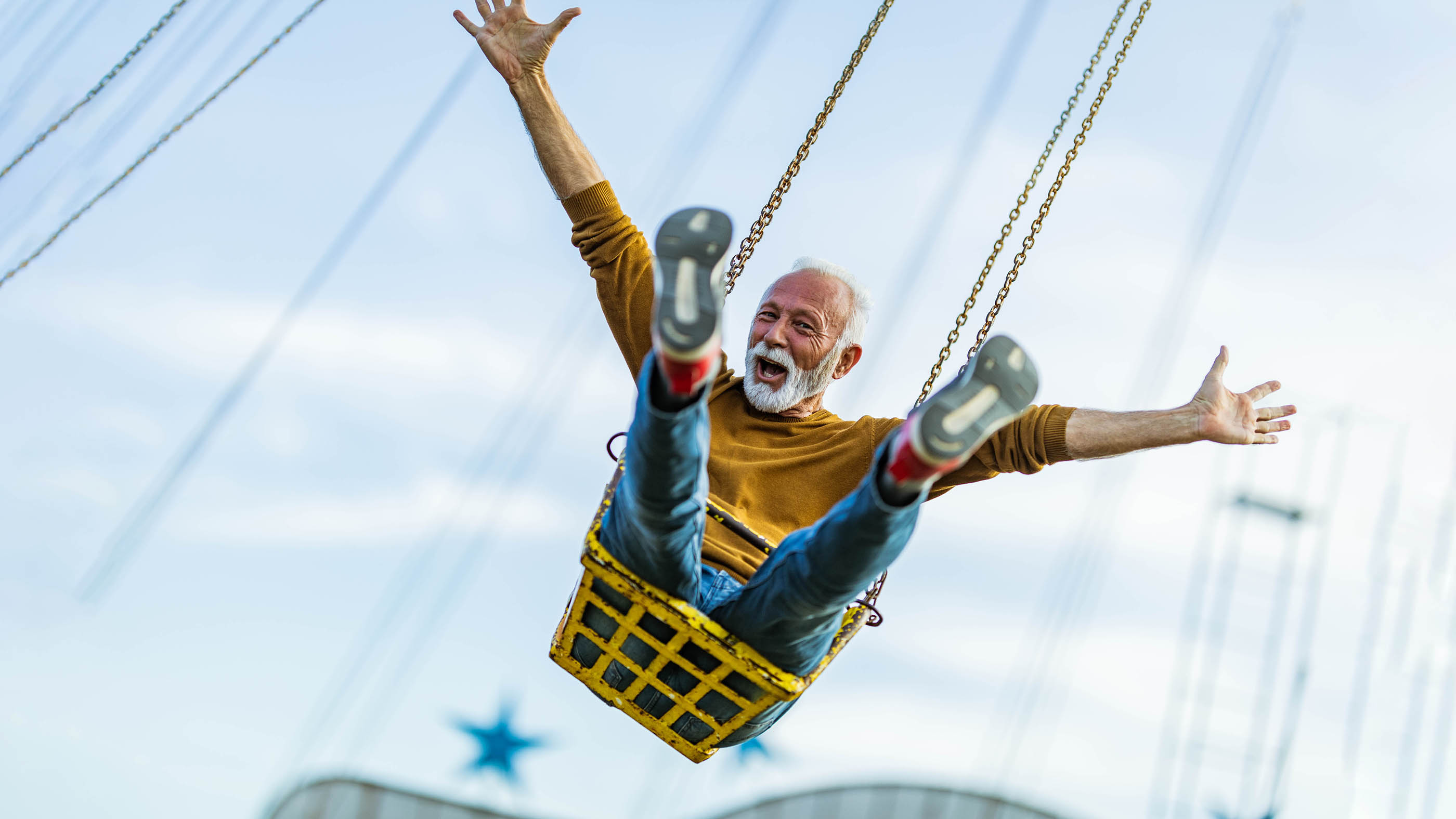 Un homme âgé souriant sur un carrousel