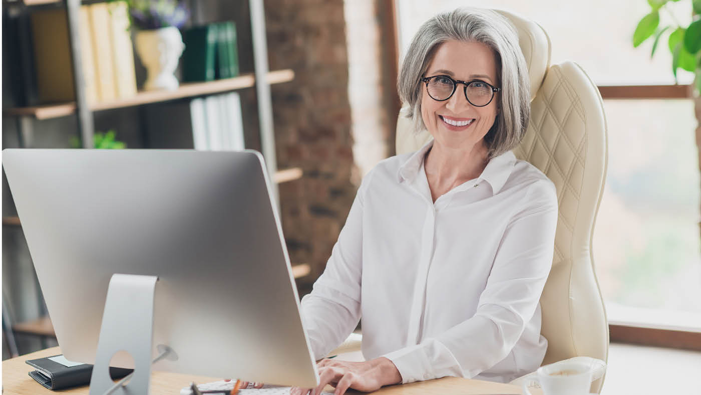 Quatre seniors sur un canapé avec des appareils numériques